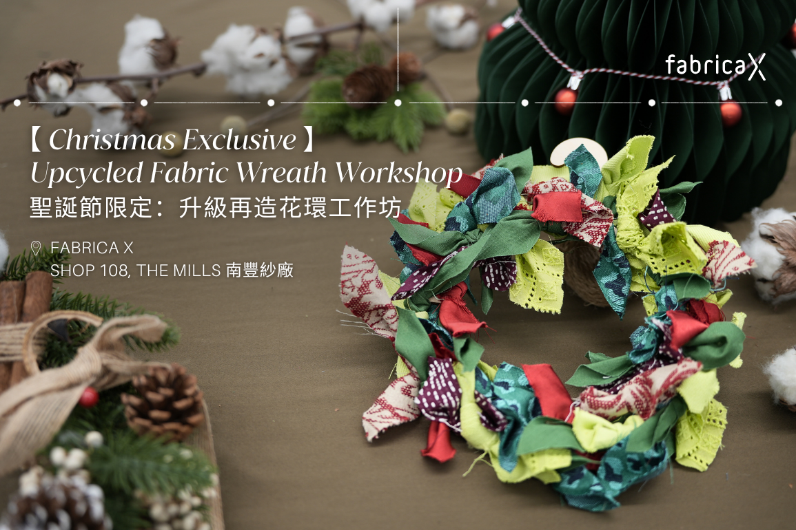 Colorful upcycled fabric wreath with Christmas decorations on a brown surface, hosted by 'Fabrica X'.